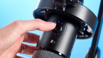 Das Maono PD1300X Podcast-Mikrofon mit XLR- und USB-C-Anschlüssen, montiert an einem Schwenkarm mit sichtbaren Stummschalt- und Bedienelementen