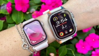 Primer plano de una persona que lleva un Apple Watch Series 10 y un Ultra 2 con flores rosas de fondo