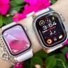 Primo piano di un utente che indossa Apple Watch Series 10 e Ultra 2 con fiori rosa sullo sfondo