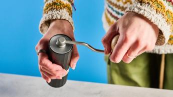 Moedor de café manual 1Zpresso Q Air sobre um fundo azul