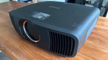 Домашний кинотеатр-проектор Epson EH-QB1000 на деревянном столе, с видом немного справа