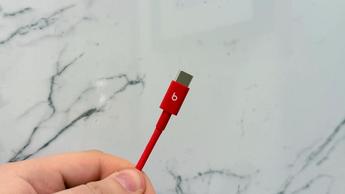 En hånd holder et Beats-hovedtelefonkabel