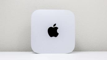 Apple Mac mini M4 stående upprätt på ett skrivbord med synlig Apple-logotyp