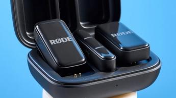 Das Rode Wireless Micro Mikrofon-Set mit schwarzem Ladecase und zwei schwarzen Sendermikrofonen vor blauem Hintergrund