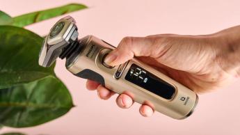 Persona che preme il pulsante di accensione sul rasoio elettrico Philips S9000 Prestige