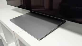 Телевизор Samsung S90F OLED 48 дюймов на белой деревянной тумбе, видна нижняя часть и подставка телевизора