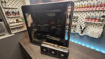 An Alienware Area-51 (2025) on a desk with a triple-slot GPU next to it to show scale