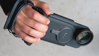 Pessoa a segurar o ShiftCam ProGrip enquanto fotografa uma paisagem ao ar livre