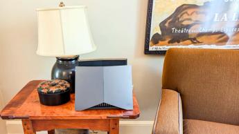 Tp-link archer ge800 gaming-router placerad på ett skrivbord i ett vardagsrum