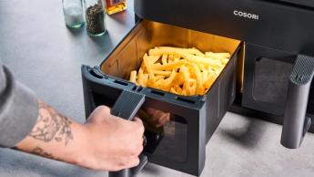 Fritadeira elétrica preta Cosori com dois cestos transparentes, luzes de controle, grelha de cozimento e espetos para kebab