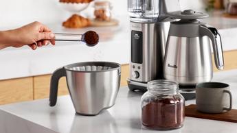 Colocando café moído fresco em uma cafeteira Breville Luxe