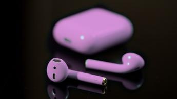 Apple AirPods med lilla nuance på sort baggrund