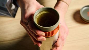 O filtro está na base de uma cafeteira portátil Wacaco Pipamoka contra um fundo azul