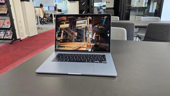 Cyberpunk 2077 vises på en MacBook i et moderne kontormiljø