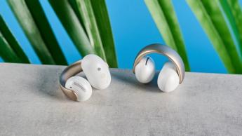Soundcore AeroClip open-ear earbuds in champagne mist against a blue backdrop