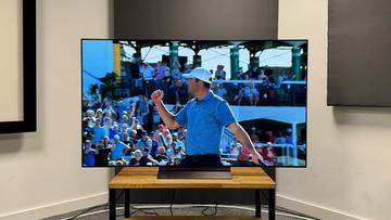 65-дюймовый OLED-телевизор LG C4 на деревянной подставке, на экране — гольфист, празднующий победу