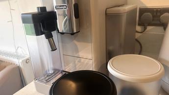 Cafetera De'Longhi Rivelia con dos compartimentos para granos en una barra de cocina