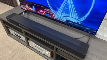 Саундбар Yamaha True X Surround 90A с беспроводными колонками и сабвуфером в минималистичной тестовой комнате с телевизором