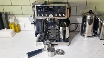 Máquina de espresso Ninja Luxe Café Pro sendo testada em uma cozinha moderna verde e branca