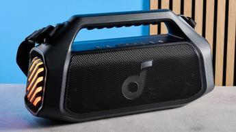Die tragbare Soundcore Boom 2 Plus Boombox mit LED-Lichtern, schwarzem Mesh-Gehäuse, BassUp- und Lichteffekt-Tasten, Tragegriff und Schultergurt