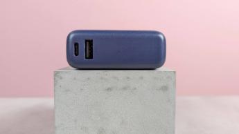Vista en primer plano de los puertos de la batería externa Xiaomi de 33W y 10.000 mAh sobre un escritorio con fondo rosa