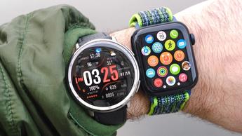 Nærbillede af Amazfit Active 2 og Apple Watch SE smartwatches, der bæres side om side på en brugers håndled