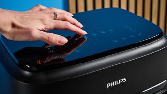 Controles touch da fritadeira elétrica Philips FlexDrawer Série 1000 destacados sobre um fundo azul