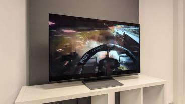 48-дюймовый OLED-телевизор Samsung S90F с изображением кокпита болида Формулы-1 на белой тумбе