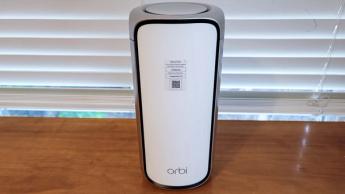 책상에 놓인 Netgear Orbi RBE973 WiFi 7 메시 라우터
