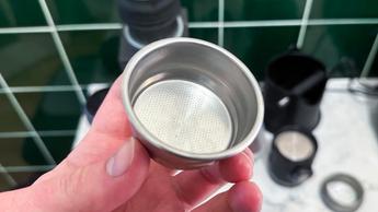 Mão segurando o cesto de café de 52mm da Wacaco Picopresso para espresso