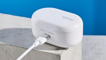 Weiße AKG N5 Hybrid Wireless Ohrhörer von Harman, präsentiert in ihrer Ladehülle mit Zubehör