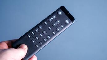 Eine Person hält einen Kanto Ren-Controller vor einer blauen Wand