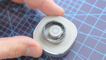 Nærbillede af Ringconn Gen 2 Air smart-ringen, der hviler på sin magnetiske opladerdock