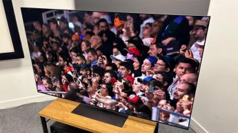 65-дюймовый OLED-телевизор LG G5 на деревянной подставке показывает сцену из сериала Netflix «Формула-1: Гонять, чтобы выживать».