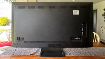 Вид сзади телевизора LG 65QNED93 LCD на деревянном обеденном столе