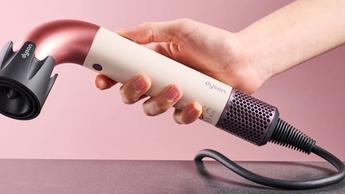 Secadora de cabello Dyson Supersonic r sostenida en la mano con accesorio de aire potente