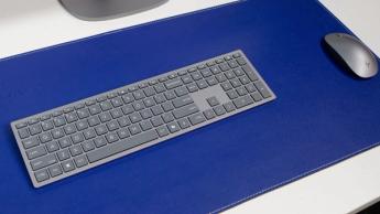 HP OmniStudio X 31,5-tommer alt-i-en stationær computer med tastatur og mus på en blå musemåtte