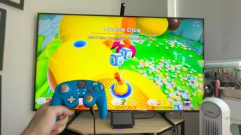 En Nintendo Switch ansluten till en TV med en trådbunden handkontroll i bruk