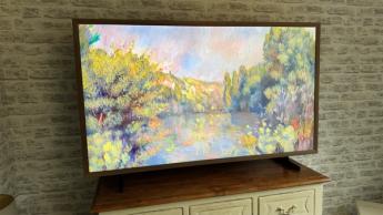 Hisense Canvas 55-inch TV on wooden chest of drawers showing colourful painting on screen