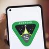 Android 15-logotyp visas på en smartphone som hålls i en hand