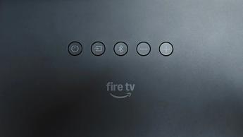 Amazon Fire TV Soundbar Plus Dolby Atmos soundbar close up on Fire TV logo and control buttons on top of unit