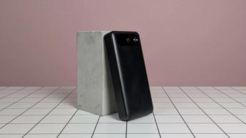 Anker 20.000mAh 87W bærbar powerbank, der hviler på et skrivebord med en lyserød baggrund