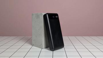 Anker 20.000mAh 87W bærbar powerbank, der hviler på et skrivebord med en lyserød baggrund
