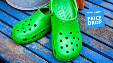 Un paio di sandali Crocs verdi su un pavimento di legno blu