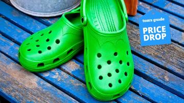 Un par de sandalias Crocs verdes sobre una tarima azul