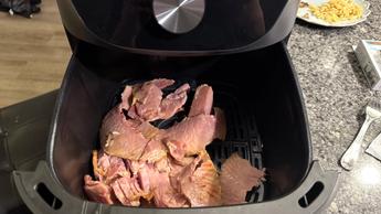 Freidora de aire Toshiba de 7.7 cuartos con canasta abierta mostrando carne cocida