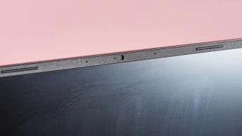 Den kompakte gaming-laptop Acer Nitro 14 vist på en koralfarvet baggrund