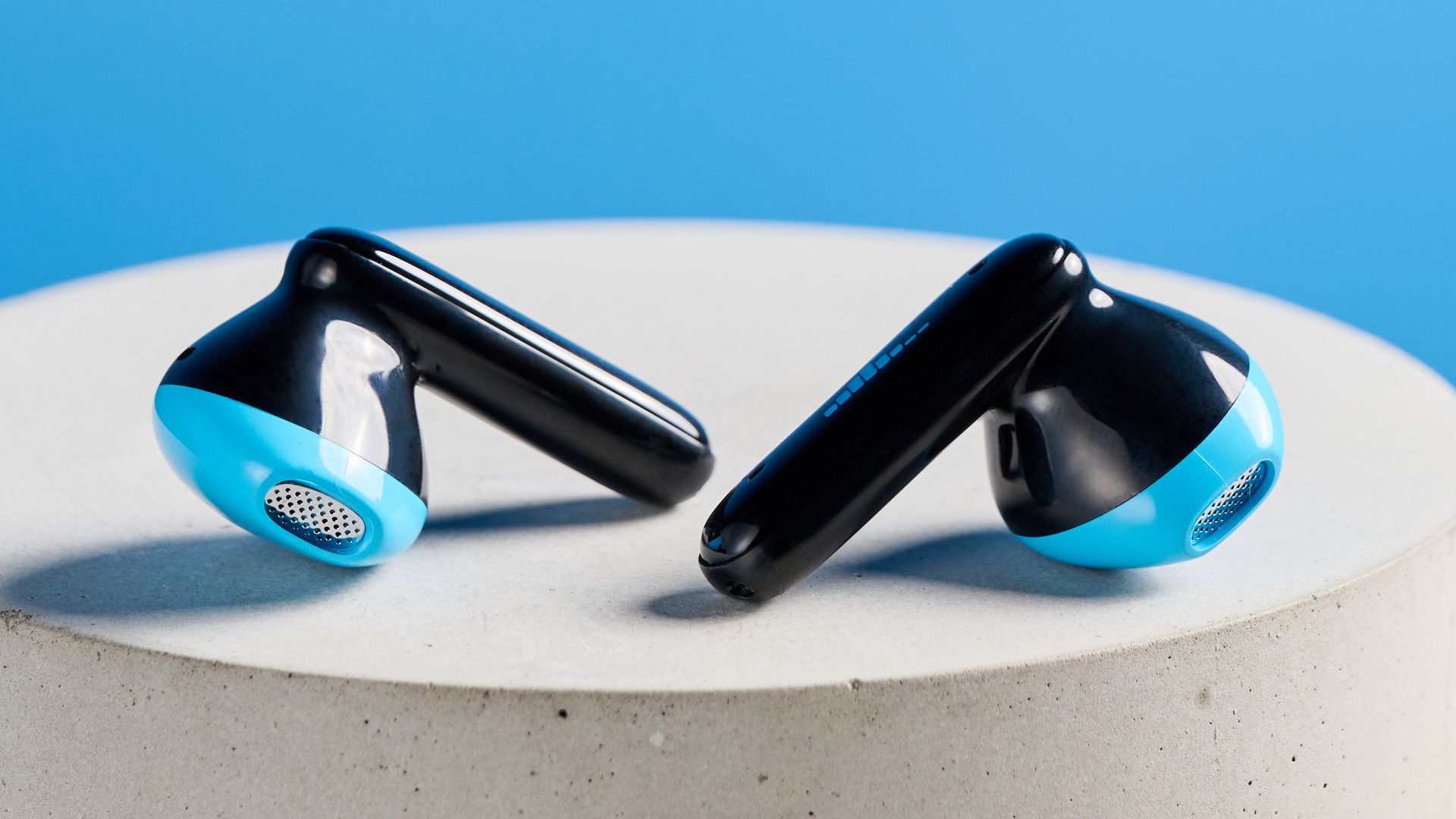 Schwarz-blaue H2O Audio Ript-Lite Ohrhörer auf blauem Hintergrund – ideal für Sport und den täglichen Musikgenuss