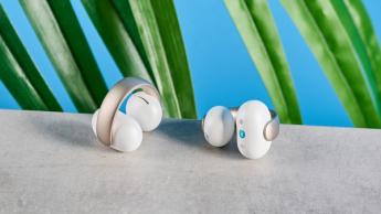 Soundcore AeroClip open-ear earbuds in champagne mist against a blue backdrop