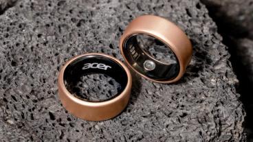 Primo piano di due anelli smart Acer FreeSense in oro rosa su una superficie che ricorda la luna